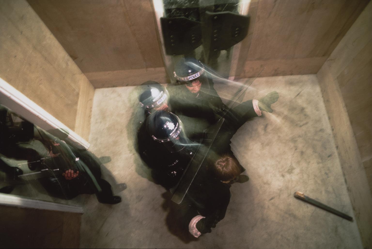 Police Photo Opportunity. Controlling Violent Man in Small Room by Chris Steele-Perkins
